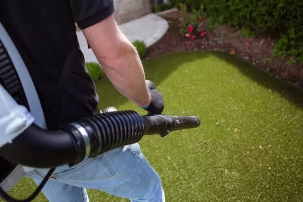 Artificial grass cleaning and debris removal in a Dubai villa garden