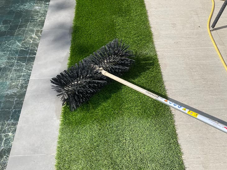 Power brush revitalising artificial grass fibres